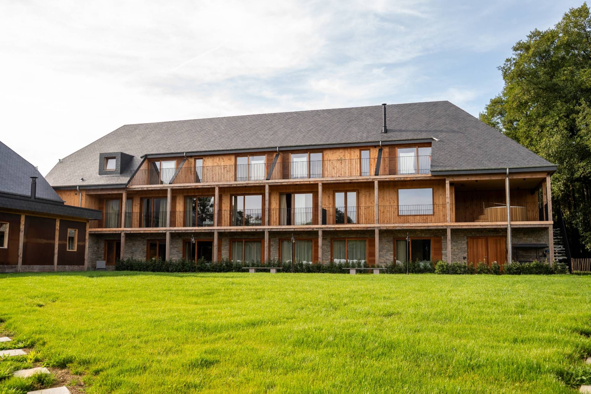 La façade en mélèze avec les balcons des chambres, côté jardin