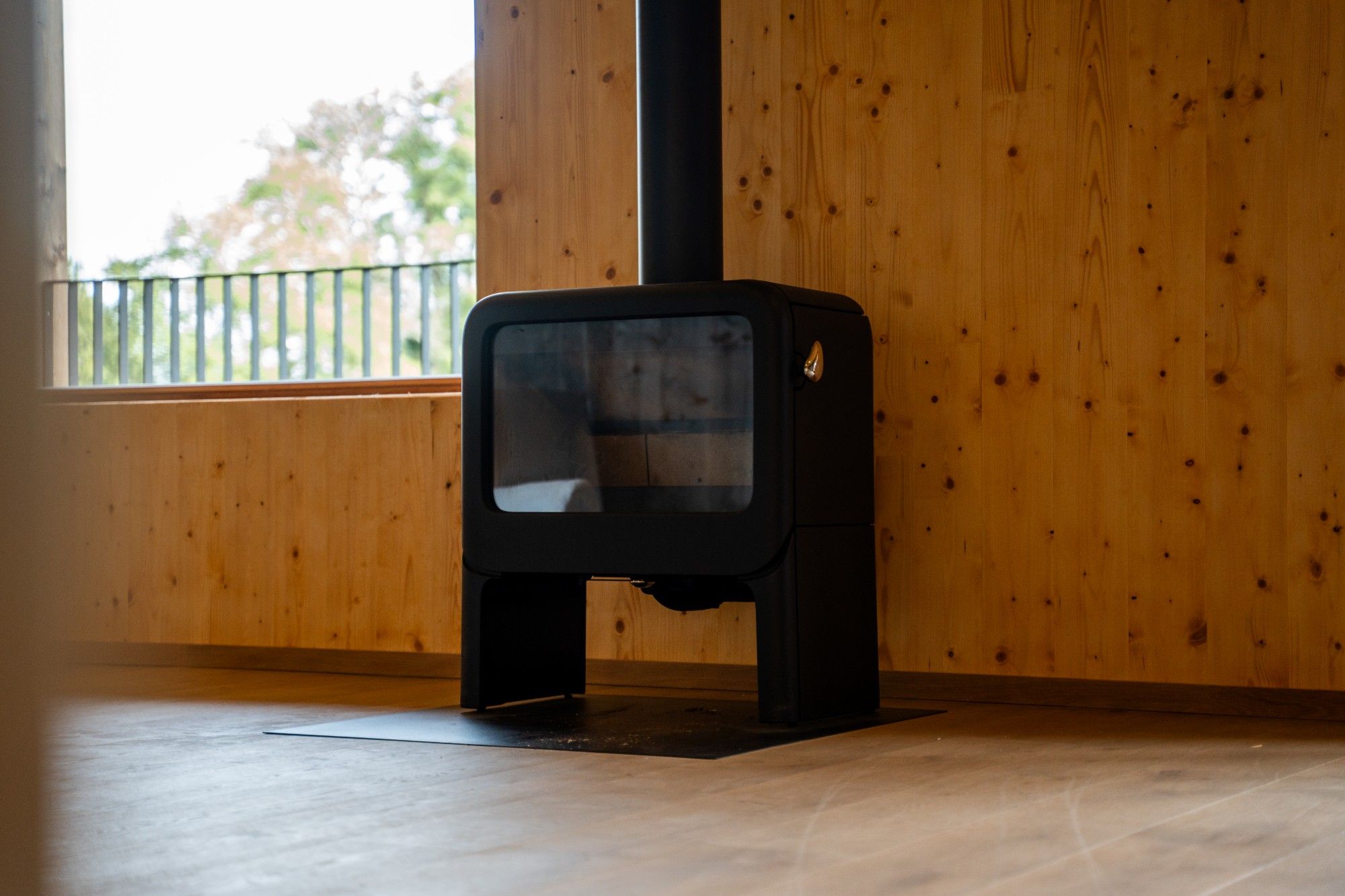 Poêle à bois dans une pièce en bois clair